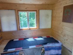Habitación con cama en una cabaña de madera en Rybnice nad Jizerou 51 en Loukov