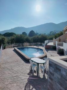 una piscina con mesa y sillas junto a ella en Villazen, en Les Cases d'Alcanar