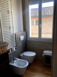 a bathroom with a toilet and a sink and a window at la pigna bizantina in Ravenna