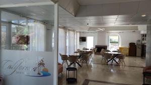 a restaurant with tables and chairs in a room at California Beach Hotel - Adults Only in Laganas