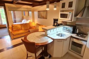 cocina y sala de estar con mesa y sofá en Luxuoso Flat Mountain Village, en Canela