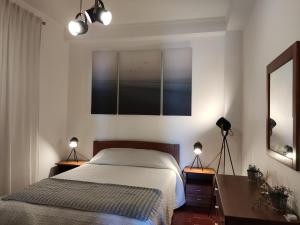 a bedroom with a bed and a desk with two lamps at Apartment by the beach! With large balcony! in São Martinho do Porto