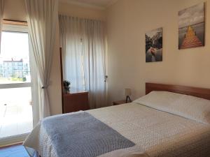 a bedroom with a bed and a large window at Apartment by the beach! With large balcony! in São Martinho do Porto