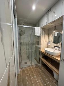 een badkamer met een douche, een wastafel en een spiegel bij San Ferdinando suite room in Napels