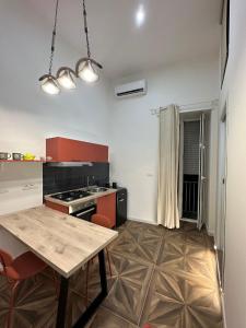 a kitchen with red cabinets and a table in it at San Ferdinando suite room in Naples +70 photos