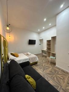 een kamer met een bank, een bed en een bureau bij San Ferdinando suite room in Napels