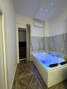 una grande vasca blu in una stanza bianca di San Ferdinando suite room a Napoli