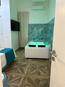 een badkamer met een bad en een televisie in een kamer bij San Ferdinando suite room in Napels