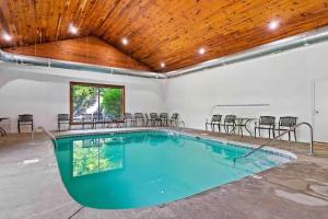 a large swimming pool with chairs and a wooden ceiling at 2-Bedroom Cabin with 2 Master Suites, Loft, Half-Bath and hot tub in a Serene Resort Setting in Sevierville