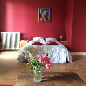 a bedroom with a bed and a vase of flowers at La Cale de Barie in Barie