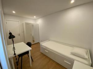 um quarto branco com uma cama e uma secretária em Carcavelos Beach Walking distance room em Oeiras