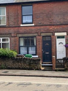 ceglany dom z czarnymi drzwiami i oknami w obiekcie Comfortable 2 bedroom home from home with parking w Nottingham