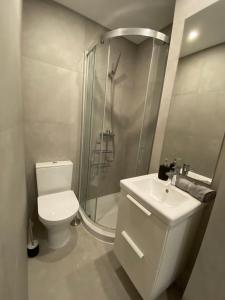 uma casa de banho com um chuveiro, um WC e um lavatório. em Carcavelos Beach Walking distance room em Oeiras