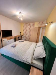 a small bedroom with a bed and a television at Apartament Andrei Muresan in Cluj-Napoca