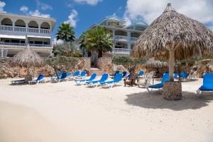 un grupo de sillas y sombrillas en la playa en Curacao Luxury Holiday Rentals, en Willemstad