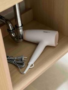 a hair dryer sitting on a shelf under a sink at Apartament Andrei Muresan in Cluj-Napoca