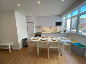 uma cozinha branca com uma mesa e cadeiras em Carcavelos Beach Walking distance room em Oeiras