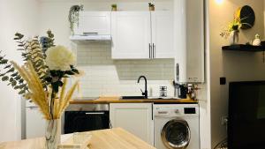 a kitchen with white cabinets and a washing machine at LE MIRAMAR Nice - Clim, Parking, Wifi et piscine in Nice