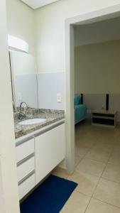 a bathroom with a sink and a mirror at Apartamento Thermas in Caldas Novas
