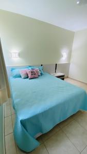 a bedroom with a blue bed with two pillows on it at Apartamento Thermas in Caldas Novas +86 photos