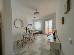 a white living room with a table and chairs at costa ballena elite in Costa Ballena