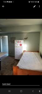 a room with a bed and a small refrigerator at ARMANI MANOR UPSTAIRS UNIT 3 quaint rustic 1br in Wildwood