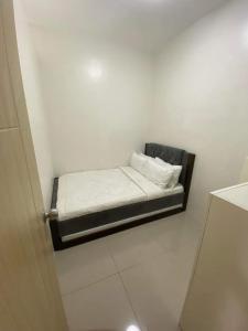 ein kleines Zimmer mit einem kleinen Bett in der Ecke in der Unterkunft Brand new 2 bedroom furnished condo unit in Vine Residences-SM Novaliches in Manila