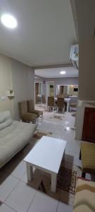 - un salon avec un canapé blanc et une table dans l'établissement Macuco Departamentos, à Puerto Iguazú