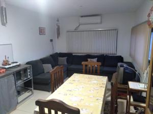 Alquiler de casa في Las Heras: غرفة معيشة مع أريكة زرقاء وطاولة