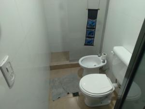 a bathroom with a white toilet and a sink at Alquiler de casa in Las Heras