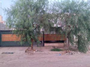 a tree in front of a building with a fence at Alquiler de casa in Las Heras