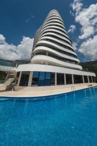 a building with a swimming pool in front of it at La barca apartments in Bečići