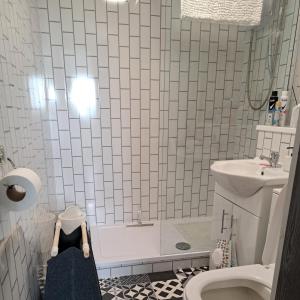 a bathroom with a shower and a toilet and a sink at The Wee Bunker in Barassie