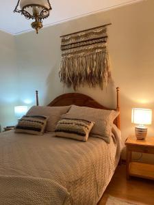 a bedroom with a large bed with two lamps and a chandelier at Nevados de chillan , edificio los coigues in Nevados de Chillan