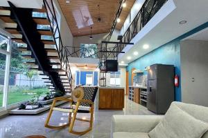 sala de estar con escalera, sofá y silla en Caribbean Blue House - Modern style 100 WiFi, en Cahuita