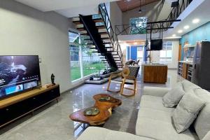 sala de estar con sofá y TV en Caribbean Blue House - Modern style 100 WiFi, en Cahuita
