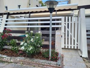 una recinzione bianca di fronte a una casa con fiori di Cap d'Agde Villa Naturiste Port Nature 3 a Cap d'Agde