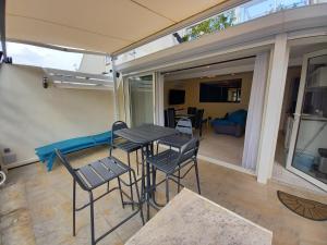 un patio con tavolo e sedie e un soggiorno di Cap d'Agde Villa Naturiste Port Nature 3 a Cap d'Agde