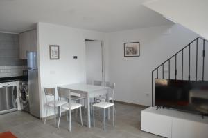 a kitchen with a table and chairs and a television at El Molino 3 in Muros de Nalón +5 photos