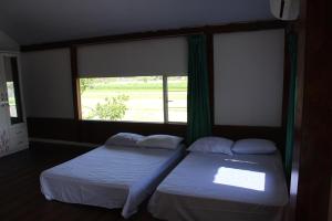 2 camas en una habitación con ventana en Georium Dunia en Prambanan