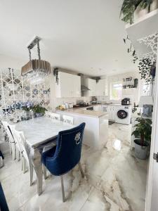 a white kitchen with a dining table and chairs at semi-detached houses in Manchester