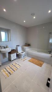a bathroom with a tub and a toilet and a sink at semi-detached houses in Manchester