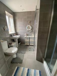 a bathroom with a toilet and a sink and a shower at semi-detached houses in Manchester