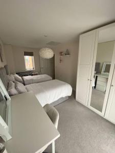 a white bedroom with a bed and a couch at semi-detached houses in Manchester