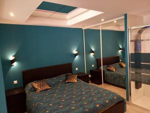 una camera con letto e parete blu di Cap d'Agde Villa Naturiste Port Nature 3 a Cap d'Agde