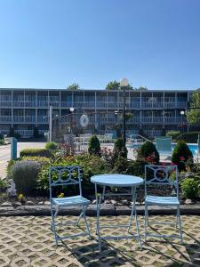 The Grand Beach Inn في أولد أوركاد بيتش: كرسيين وطاولة أمام المبنى