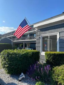 an american flag flying in front of a building at The Grand Beach Inn in Old Orchard Beach