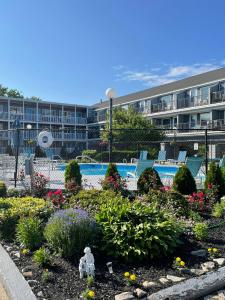 a garden with chairs and flowers in front of a building at The Grand Beach Inn in Old Orchard Beach