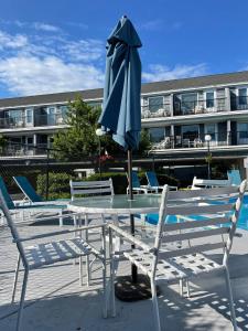 - une table et des chaises avec un parasol sur la terrasse dans l'établissement The Grand Beach Inn, à Old Orchard Beach