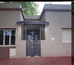 ein weißes Haus mit einer vergitterten Tür in der Unterkunft Departamento Mis Nonos 2 in Mendoza